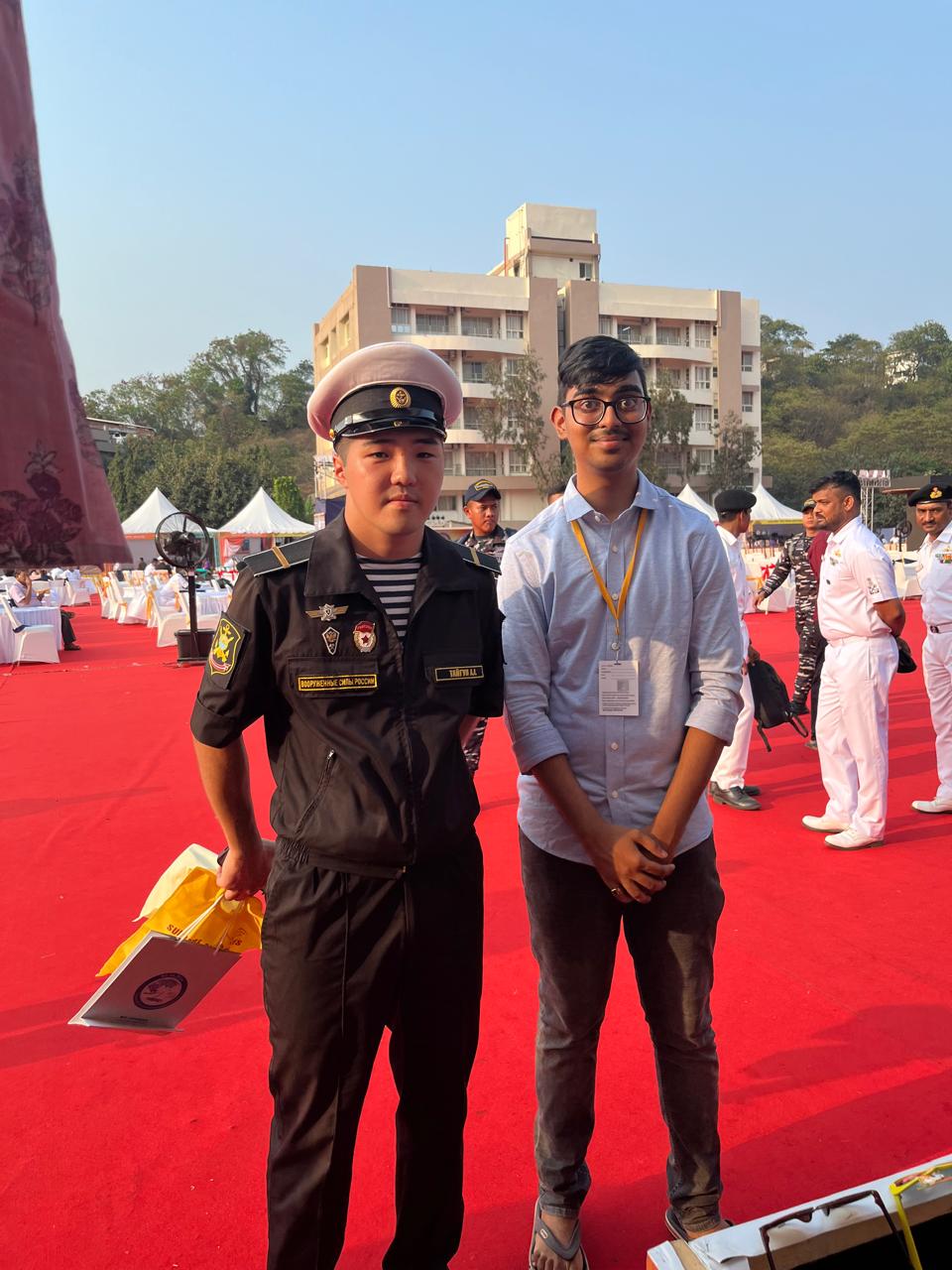 Two individuals at an outdoor event with red carpet